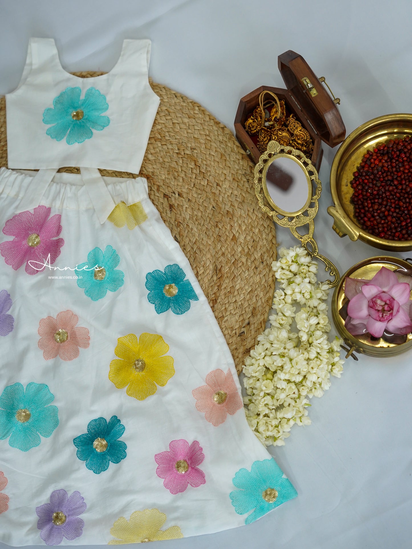 White dress with colorful floral patterns on a textured surface for girls by annies.co.in