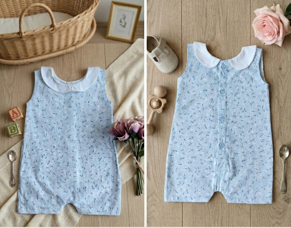 Light blue baby romper with white collar on a wooden surface with toys and flowers.