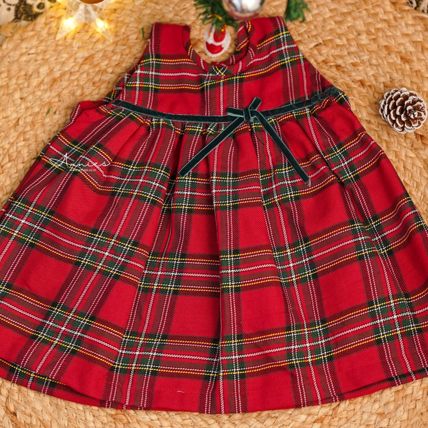 Red plaid dress on a woven surface with decorative elements