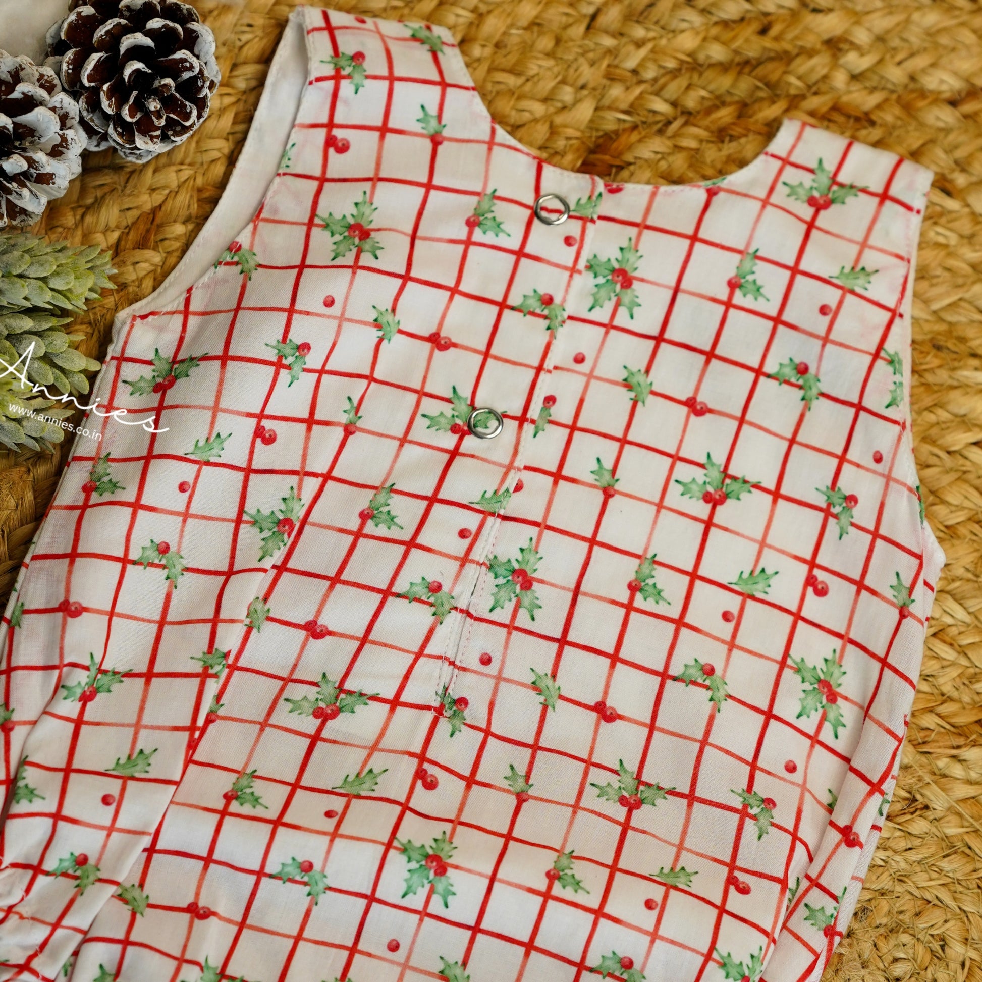 Red and white checkered fabric with Christmas patterns on a woven surface.