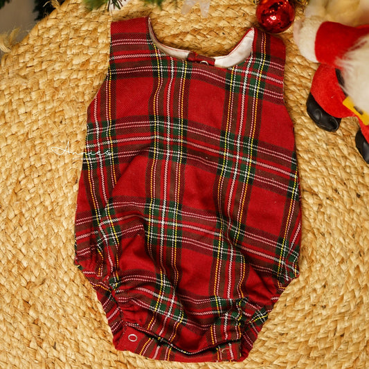 Red plaid baby romper on a woven surface