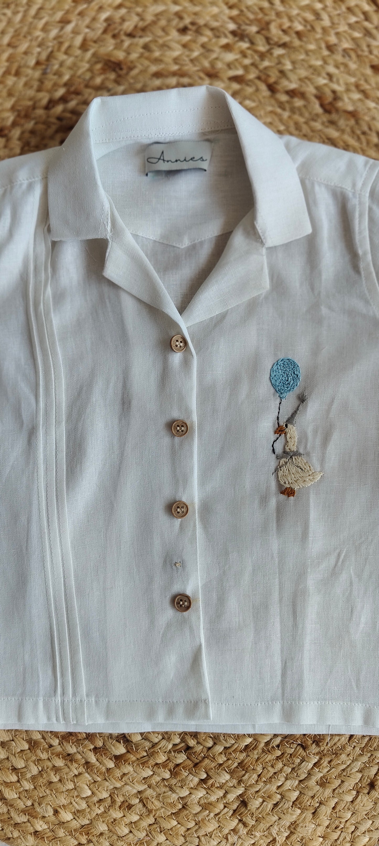 White shirt with embroidery on a textured surface