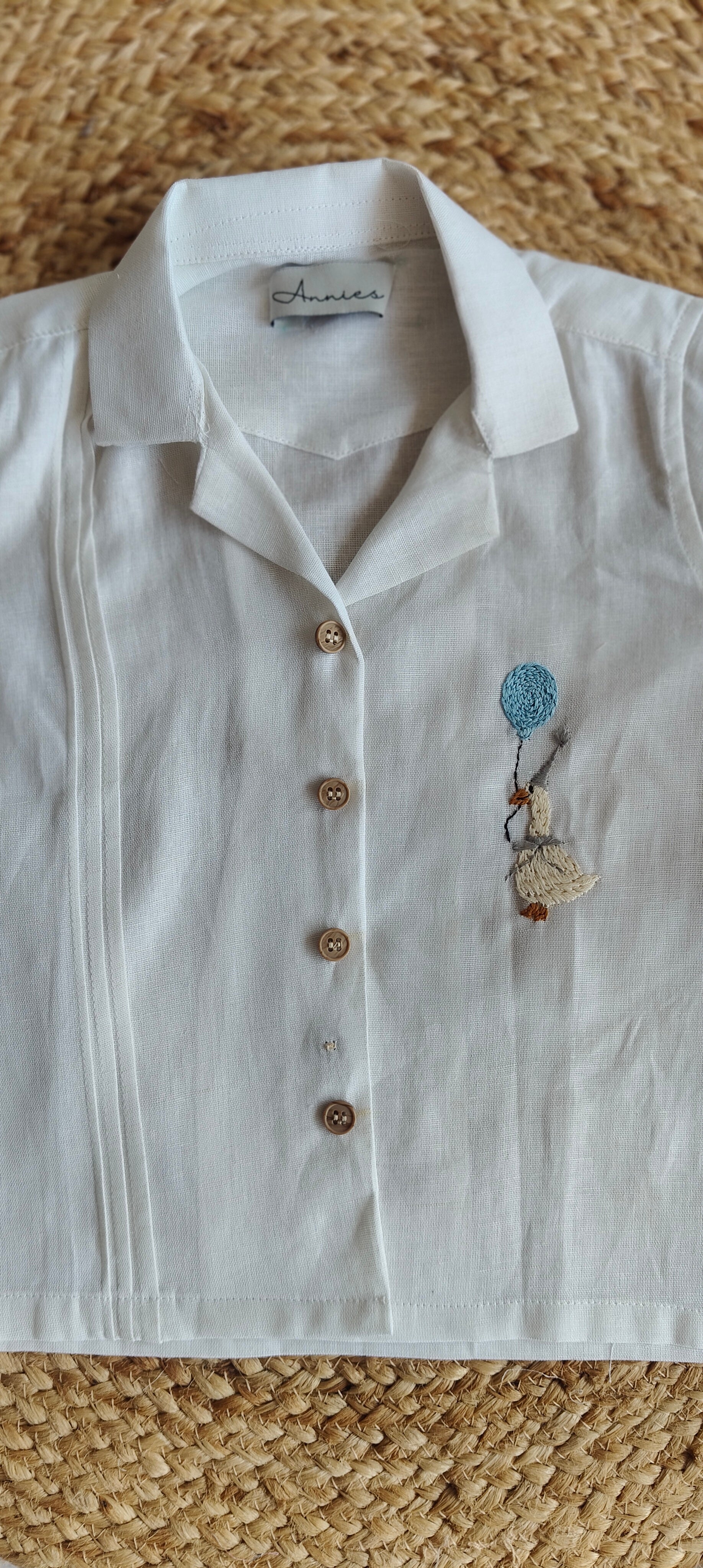 White shirt with embroidery on a textured surface