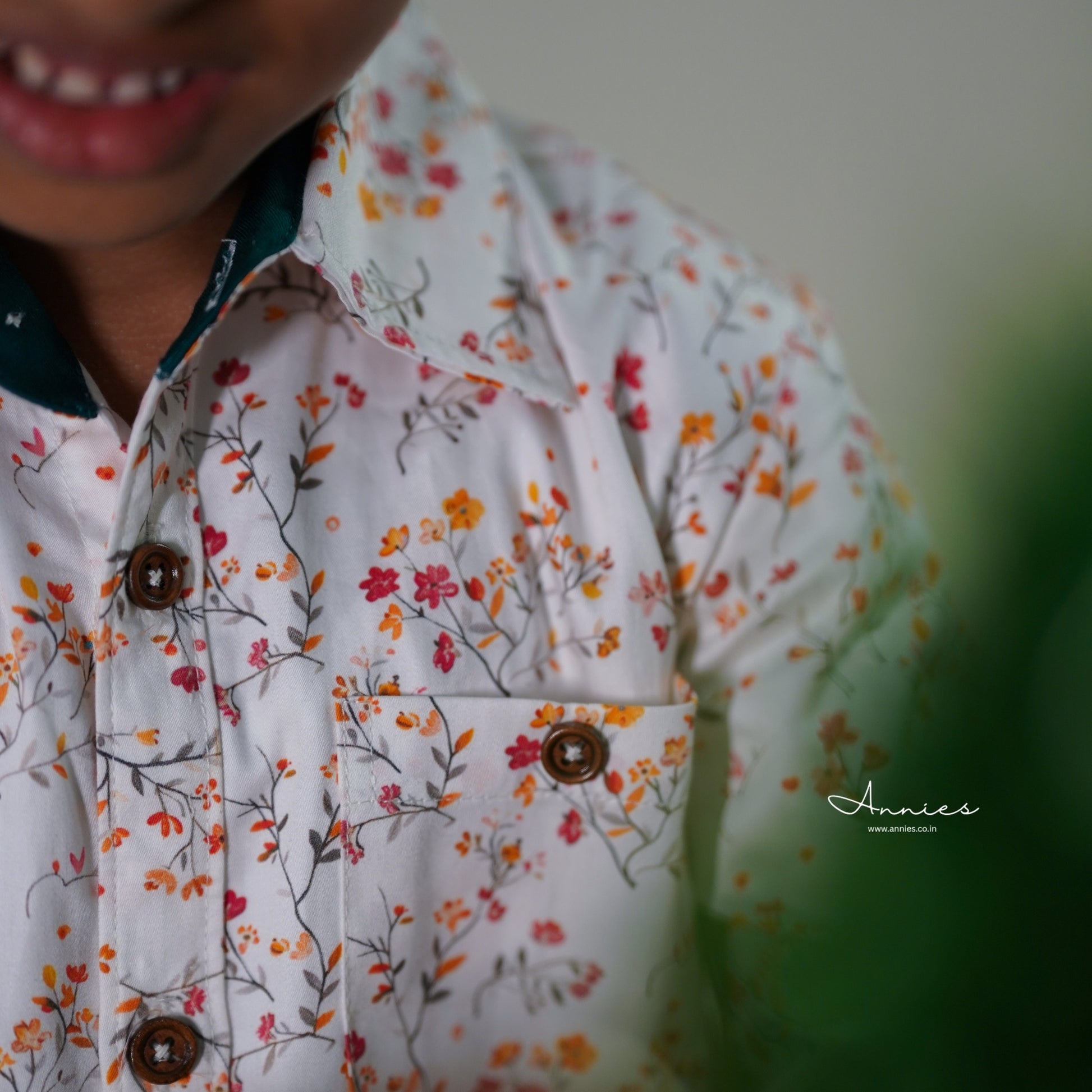 Close-up of a child wearing a floral shirt with a blurred background