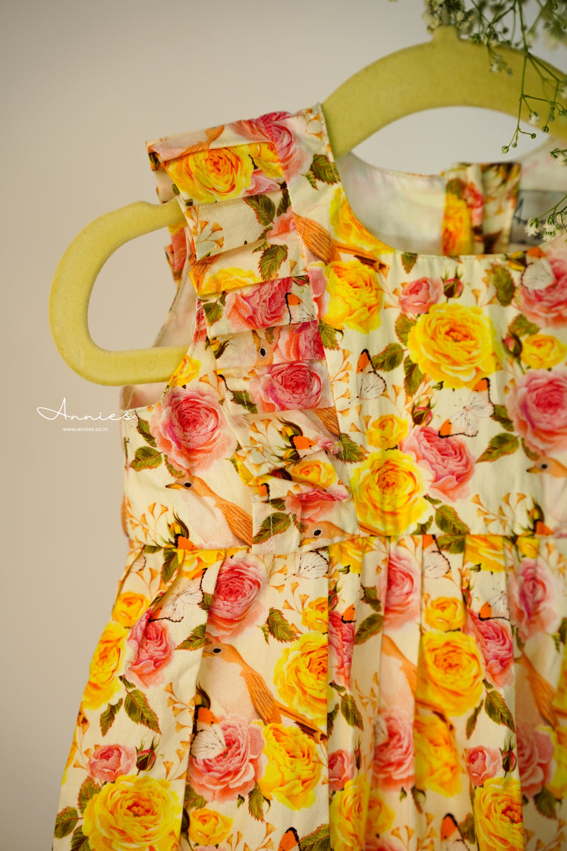 Floral dress with pink and yellow roses on a plain background