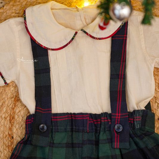 Children's outfit with white shirt and plaid skirt on a mannequin against a woven basket background.