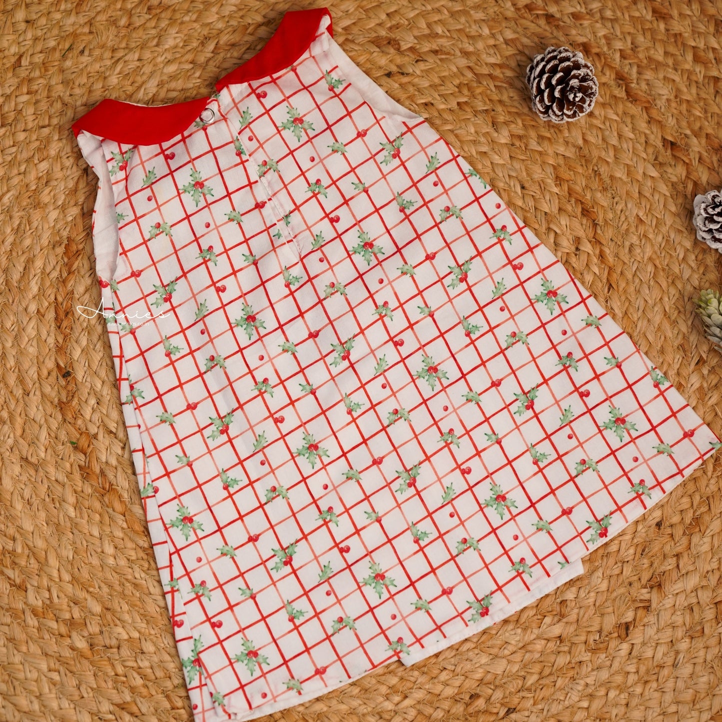 Red and white checkered dress with floral patterns on a woven surface