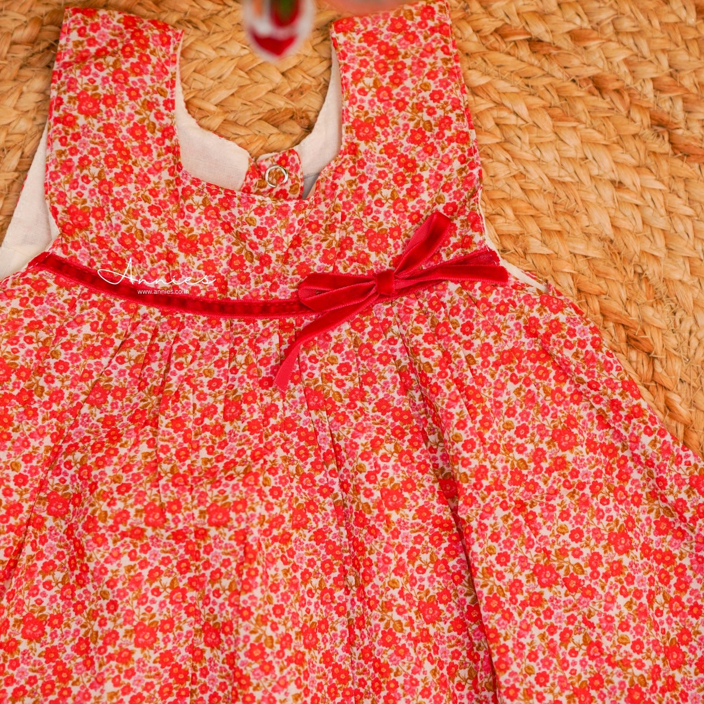 Red floral dress with a bow on a woven surface