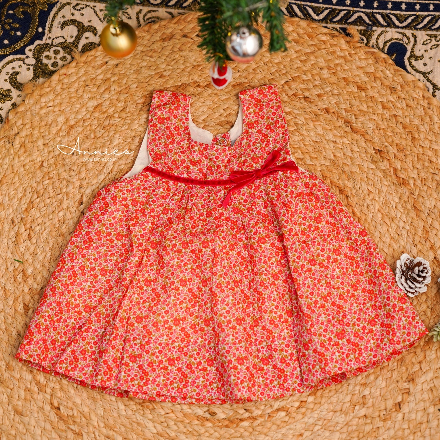 Red floral dress on a woven mat with Christmas decorations