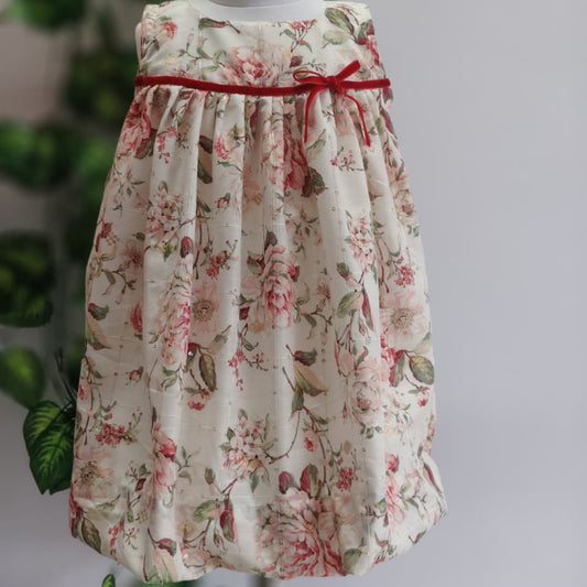 Floral dress with a red ribbon on a gray background
