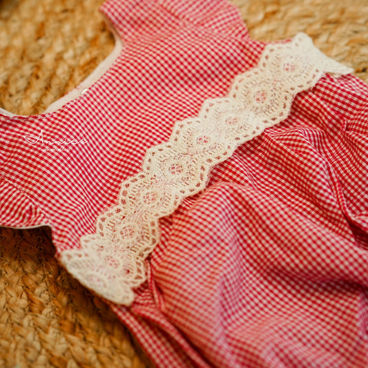 Red checkered fabric with lace trim on a woven surface