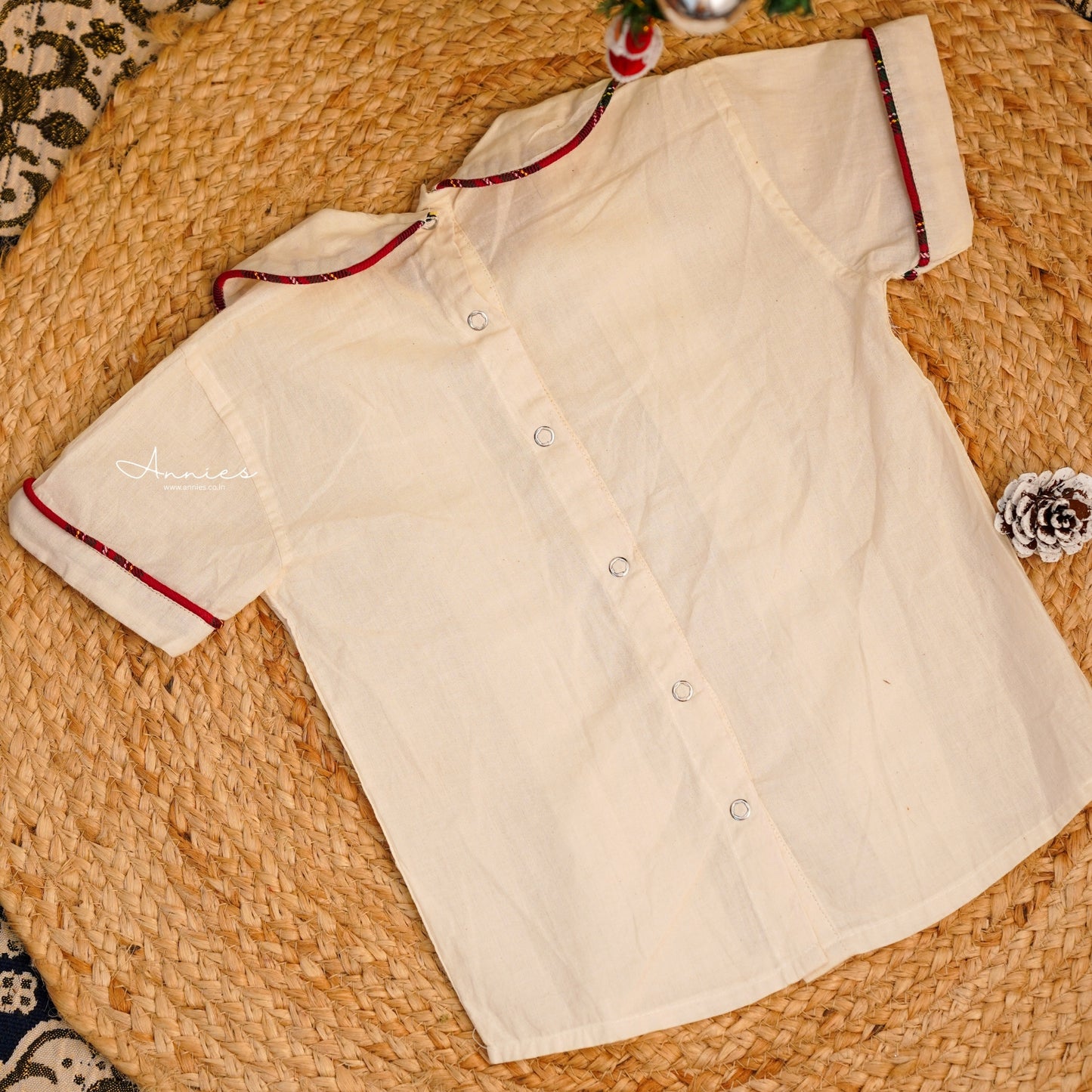 White shirt with red trim on a woven surface