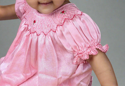A girl wearing rosie_smocked_bishop_dress by Annies