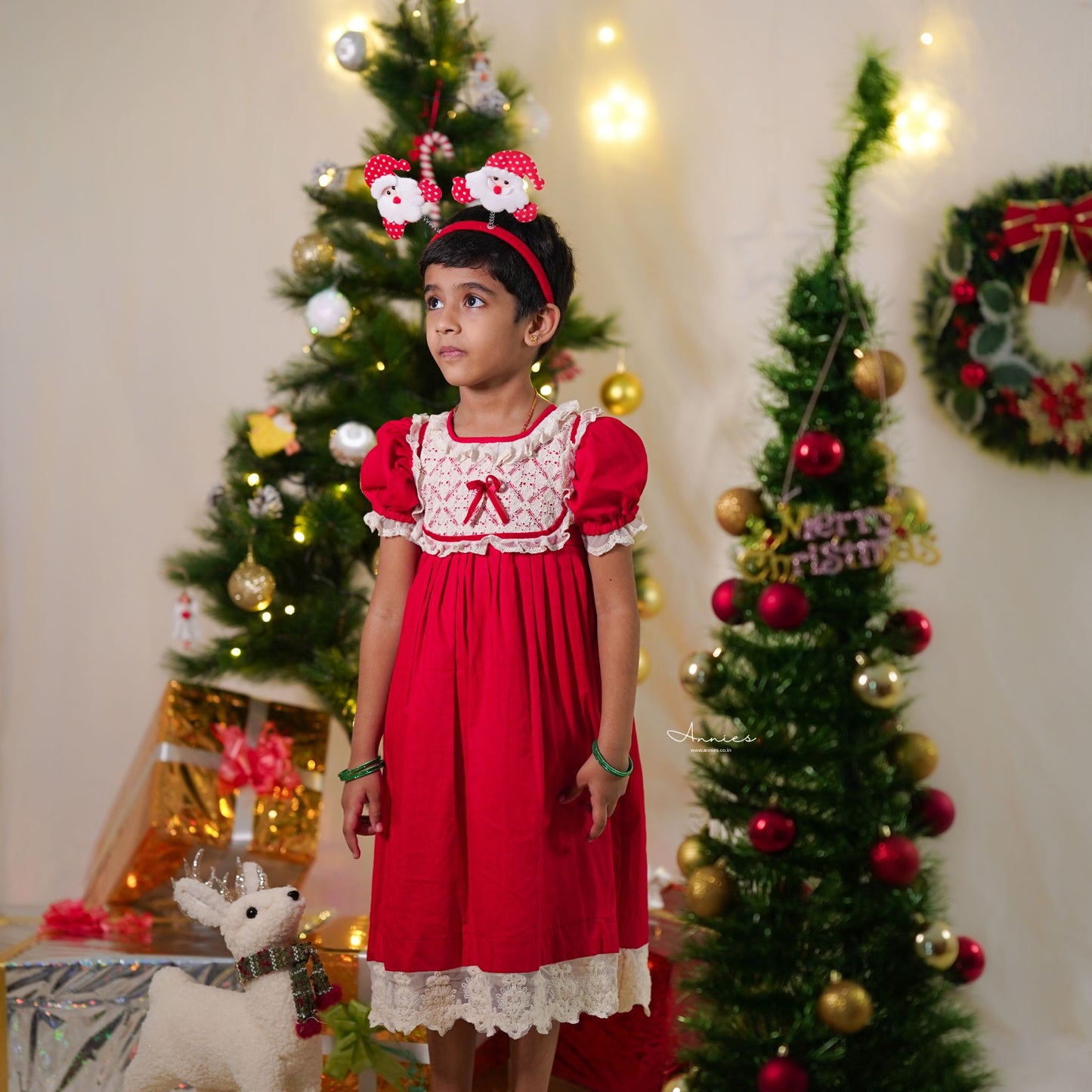 Young girl in a red dress with Christmas decorations in the background