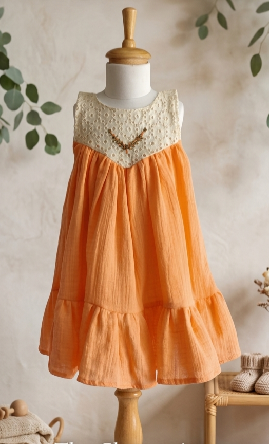 Orange dress on a mannequin with greenery and 'Little Seed Collective' text.